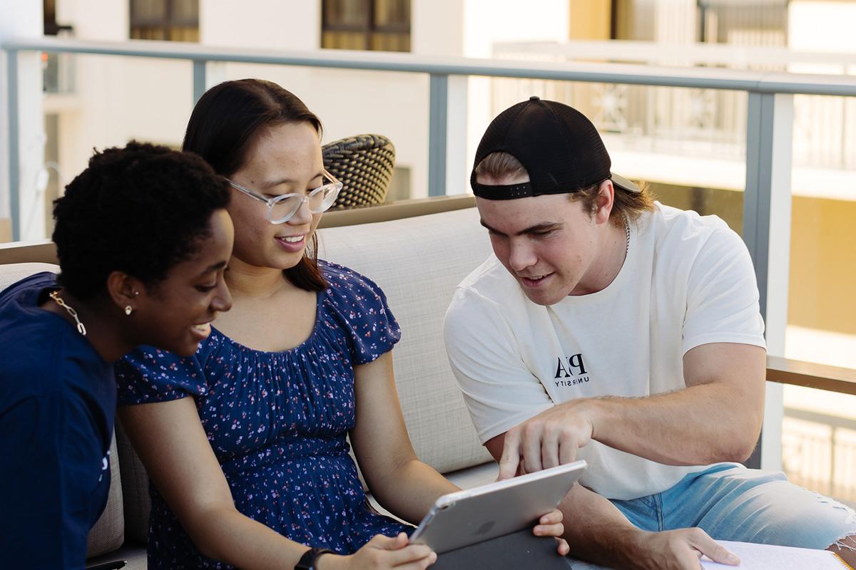 Students from the bachelor of general studies program study together on a balcony.